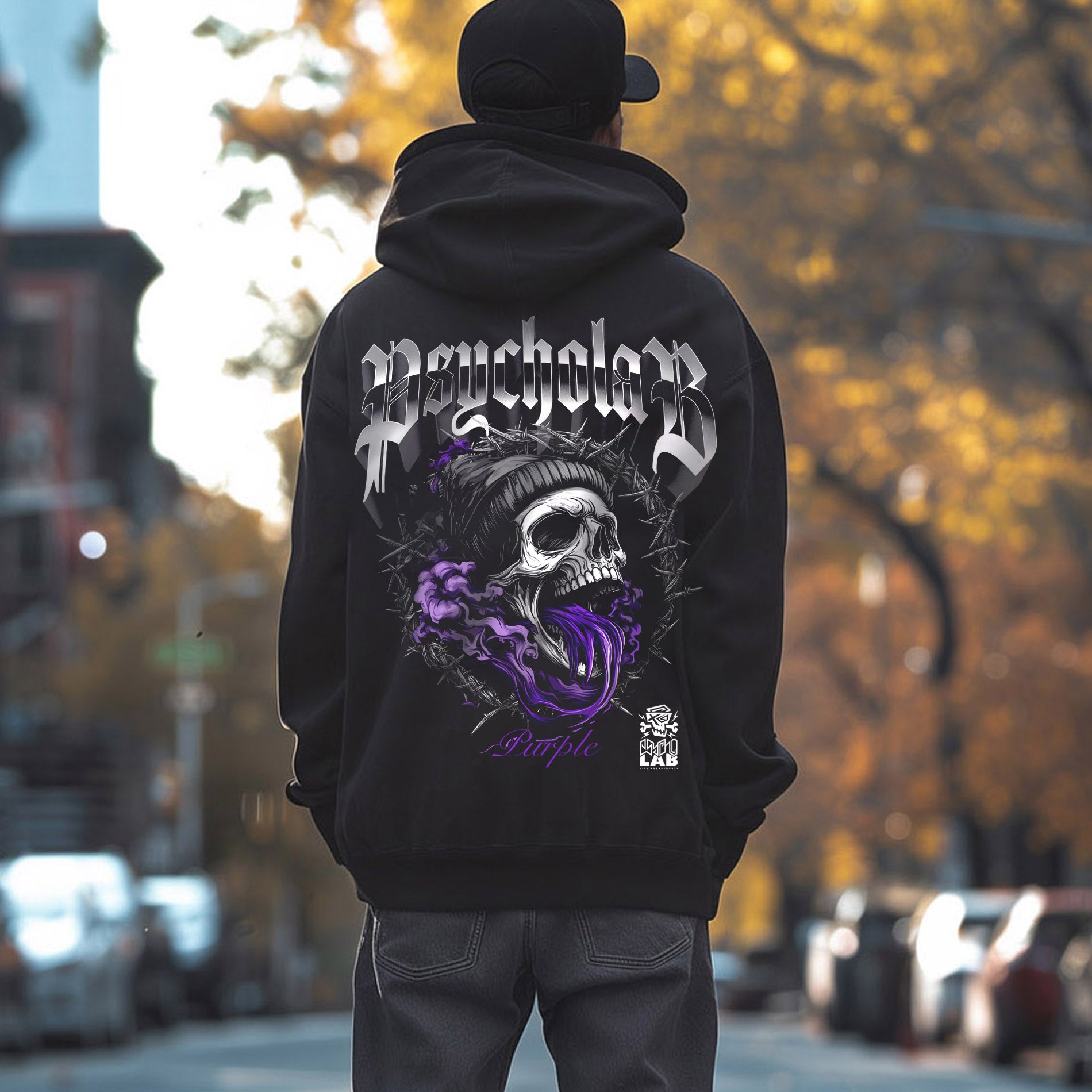 Mann, der einen lila PsychoLab Hoodie mit auffälligem Totenkopf-Design auf der Rückseite und PsychoLab Schriftzug in Grün auf der Vorderseite trägt, ideal für urbane Streetwear.