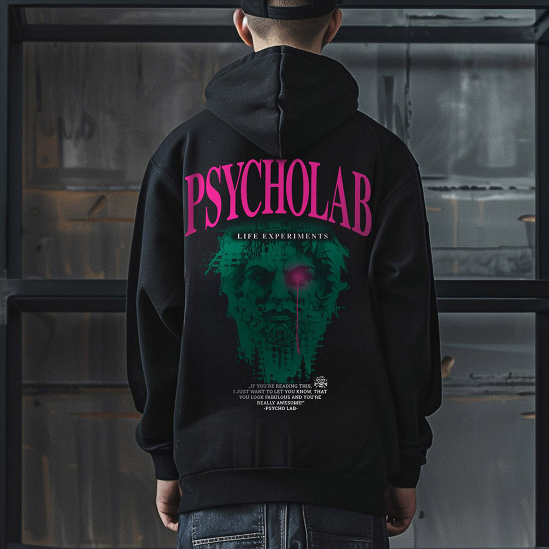 Rückansicht eines Mannes in schwarzem PsychoLab Hoodie mit Totenkopf und großem pinkem Schriftzug